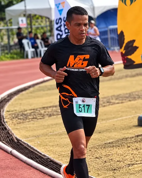 Atleta da MG correndo na pista de atletismo